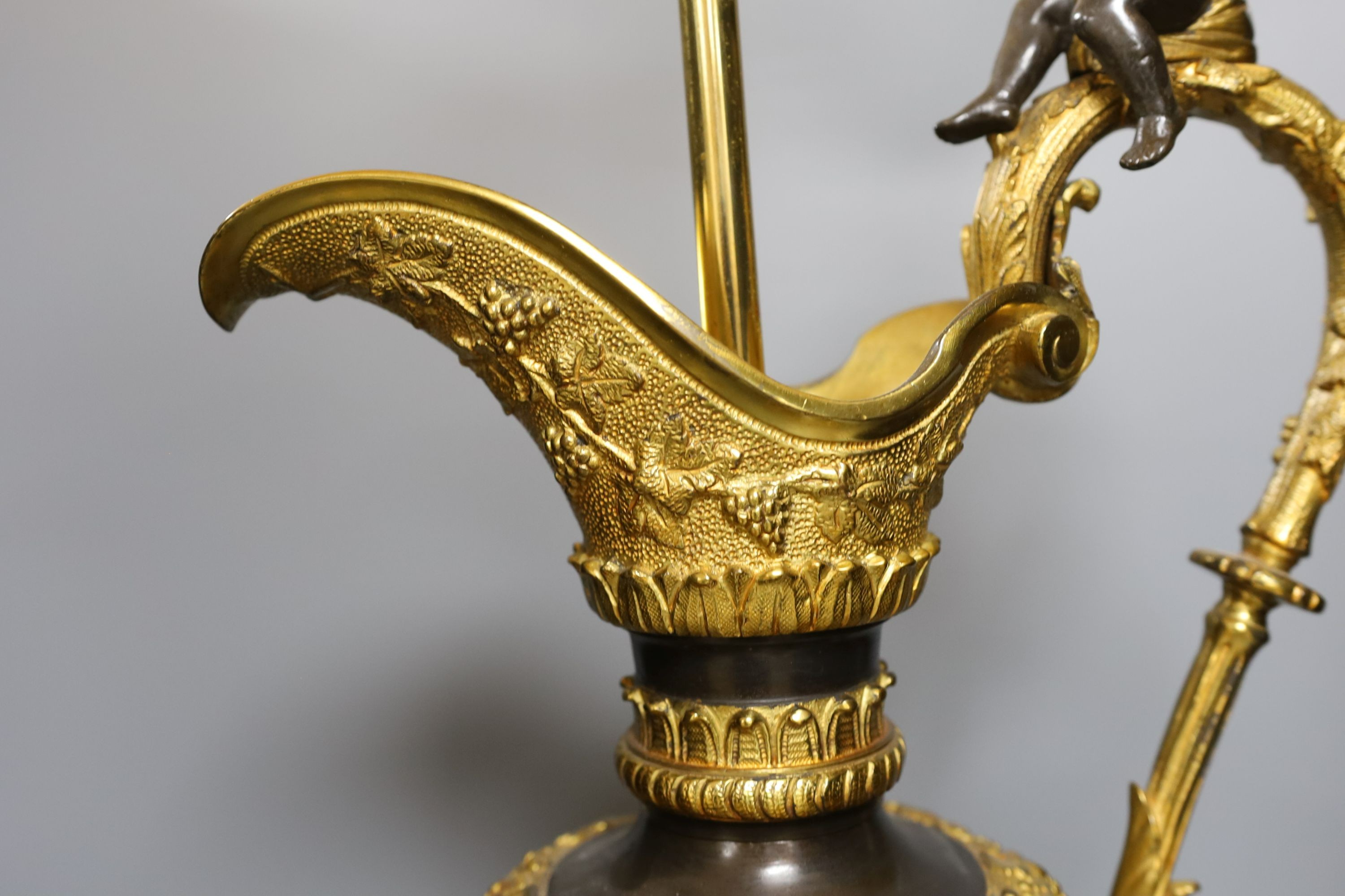 A large decorative bronze and ormolu 'ewer' lamp with seated cherub - 75.5cm tall